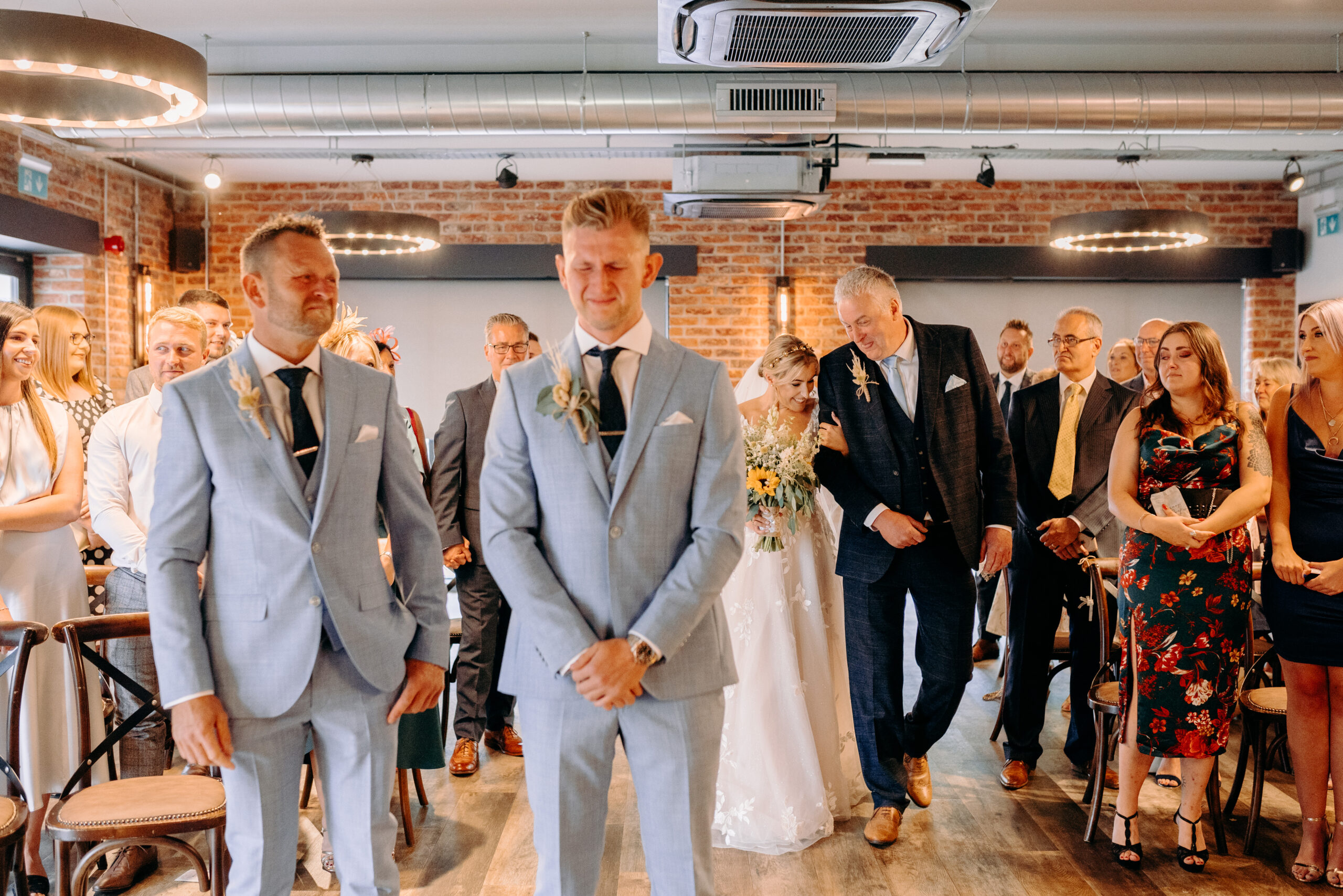 Groom waiting at the top of the aisle for his bride