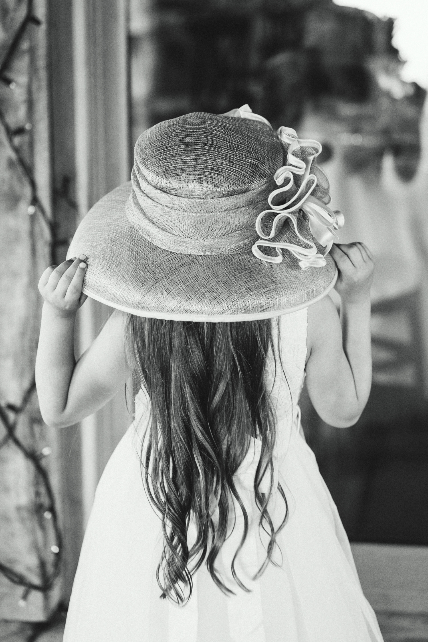 photo of young girl with ladies hat on in black and white