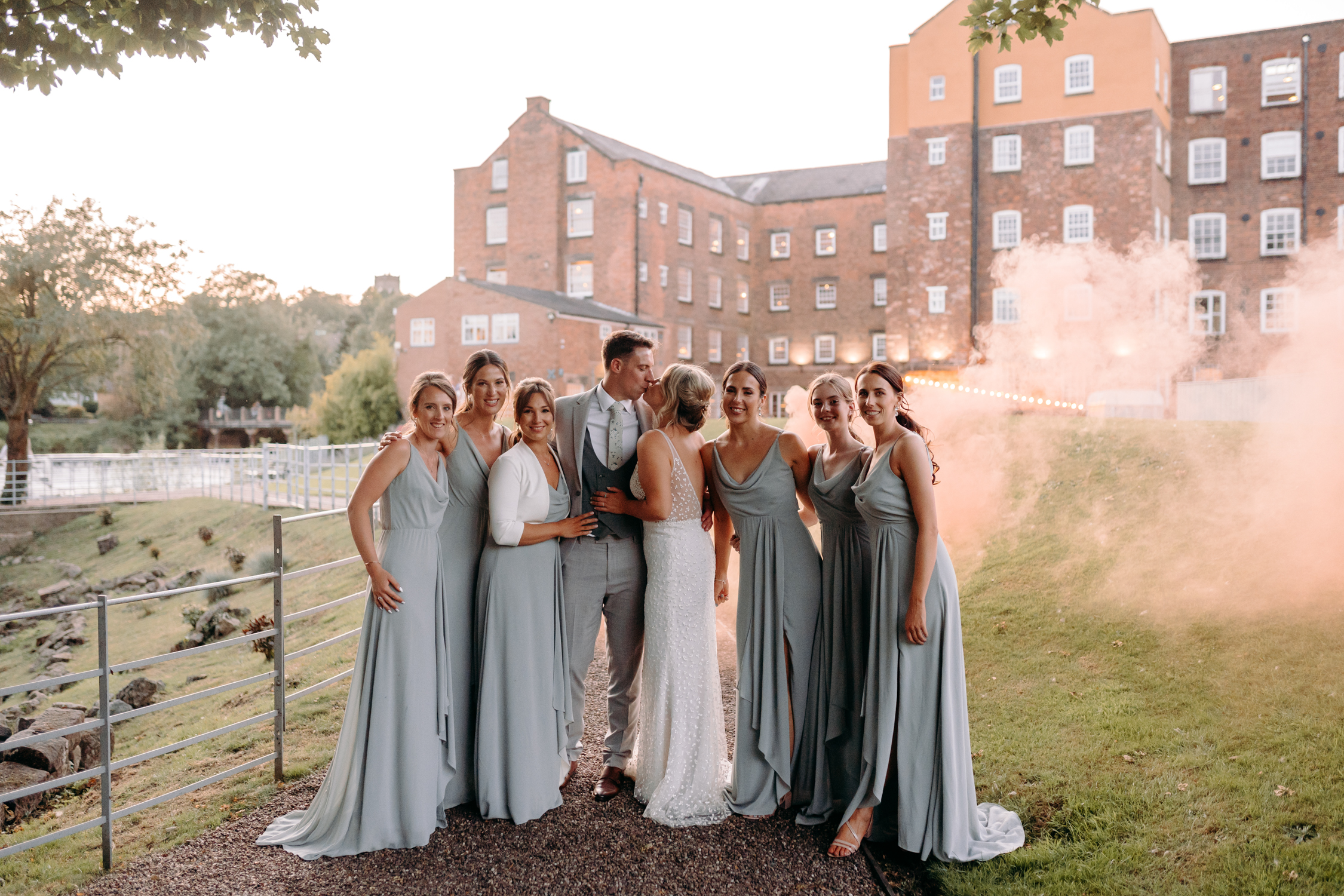 Bride and groom with bridesmaids and an orange smoke bomb