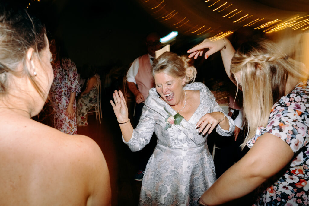 natural, fun dance floor photography of bride and mum at village hall wedding