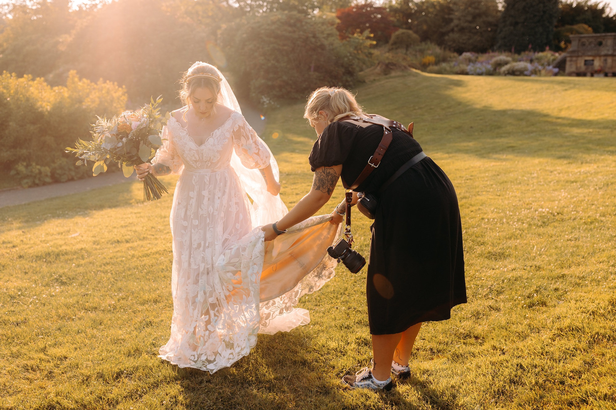Derbyshire wedding photographer helping a bride with her dress
