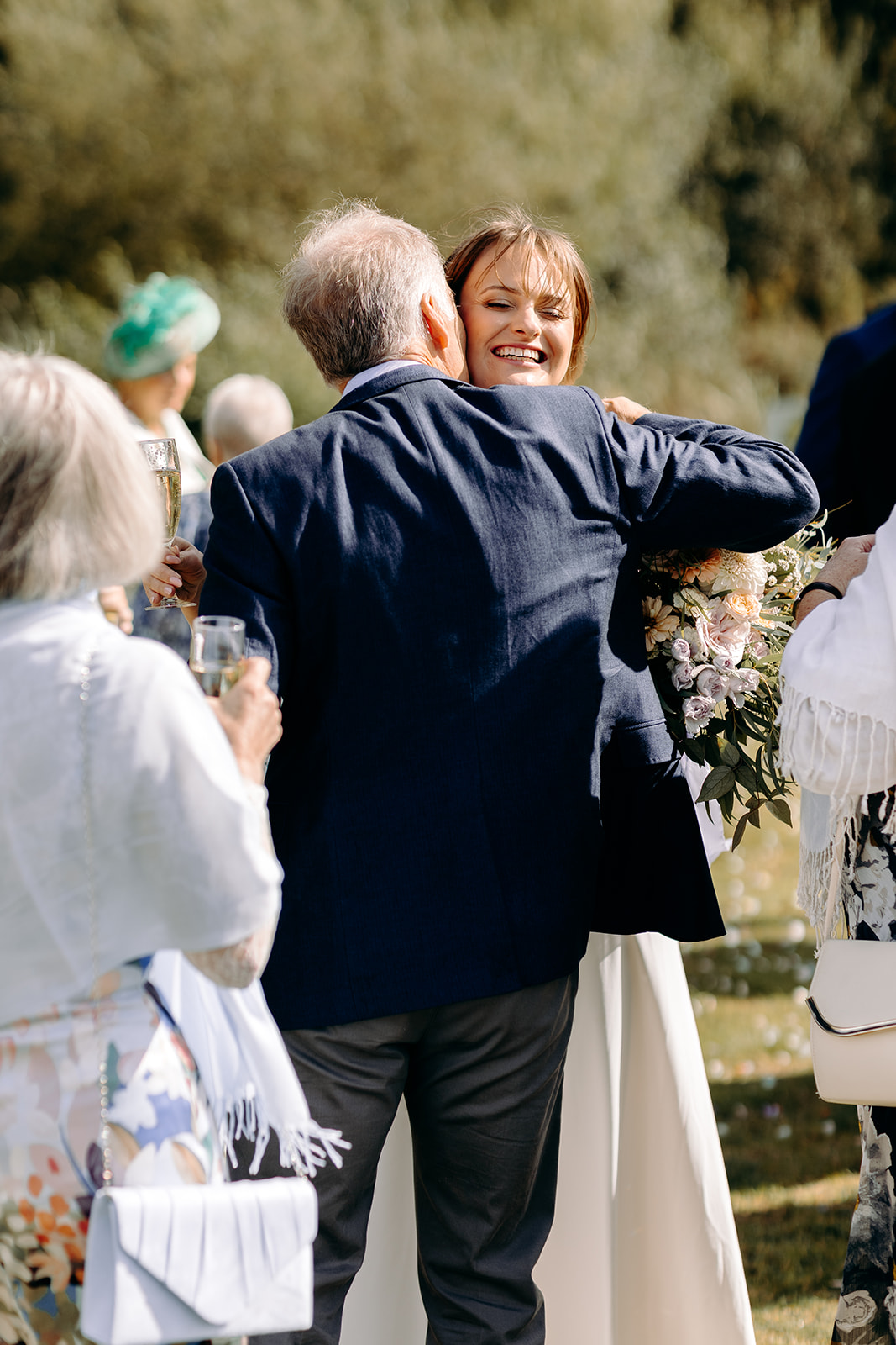Guest hugging the bride during drinks reception, fun and emotional Derbyshire wedding moment.