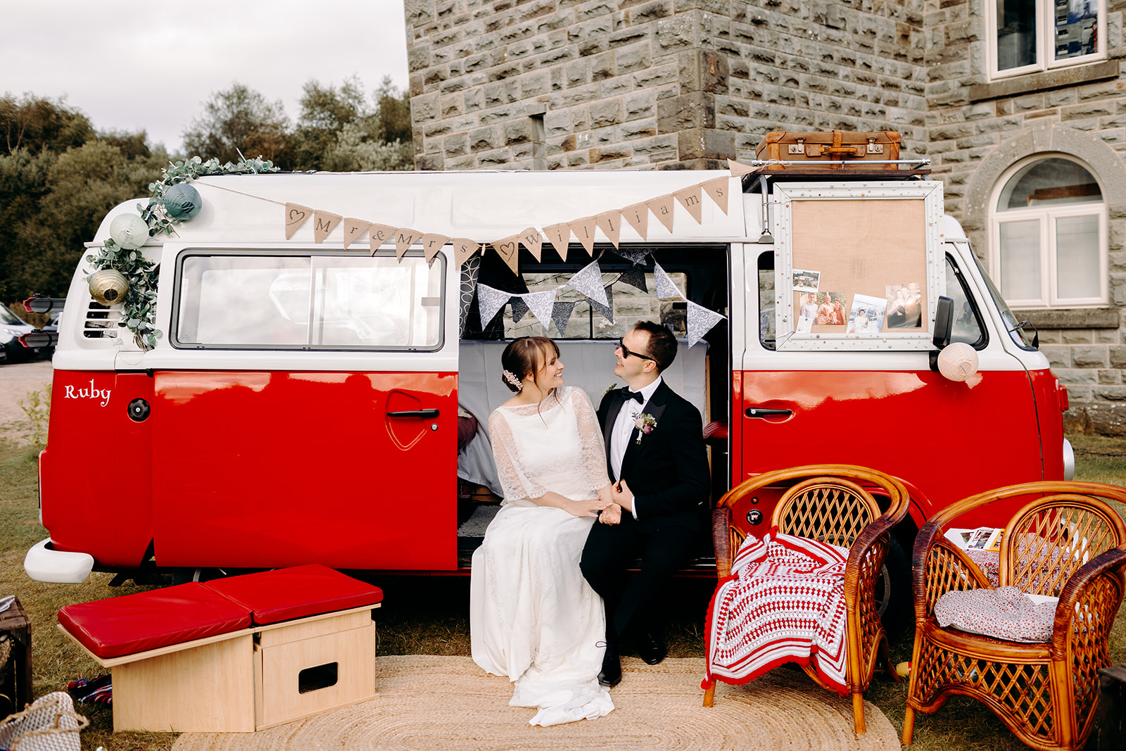 Bride and groom sitting on a red vintage VW camper van outside Darwin Lakes Holiday Village.