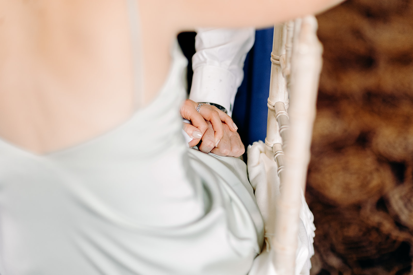 Bridesmaid and partner holding hands whilst listening to the speeches at Peak District wedding.