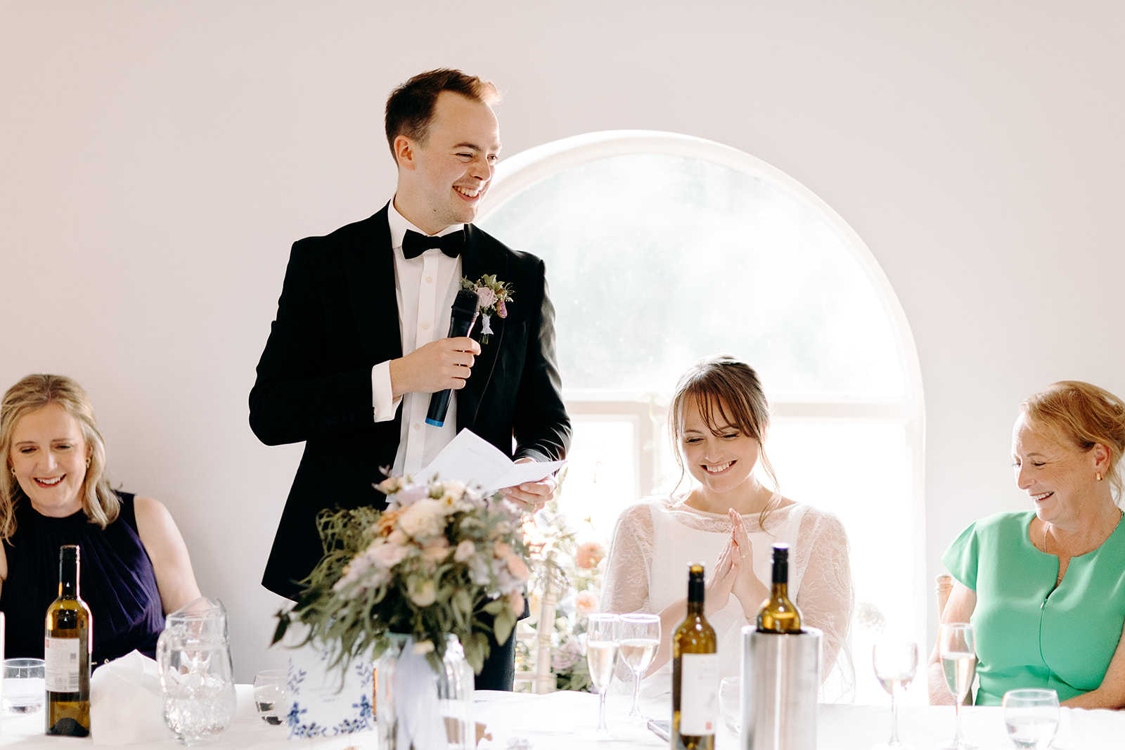 Bride smiling, seated in her gown with her dad beside her — sweet candid Derbyshire wedding moment.