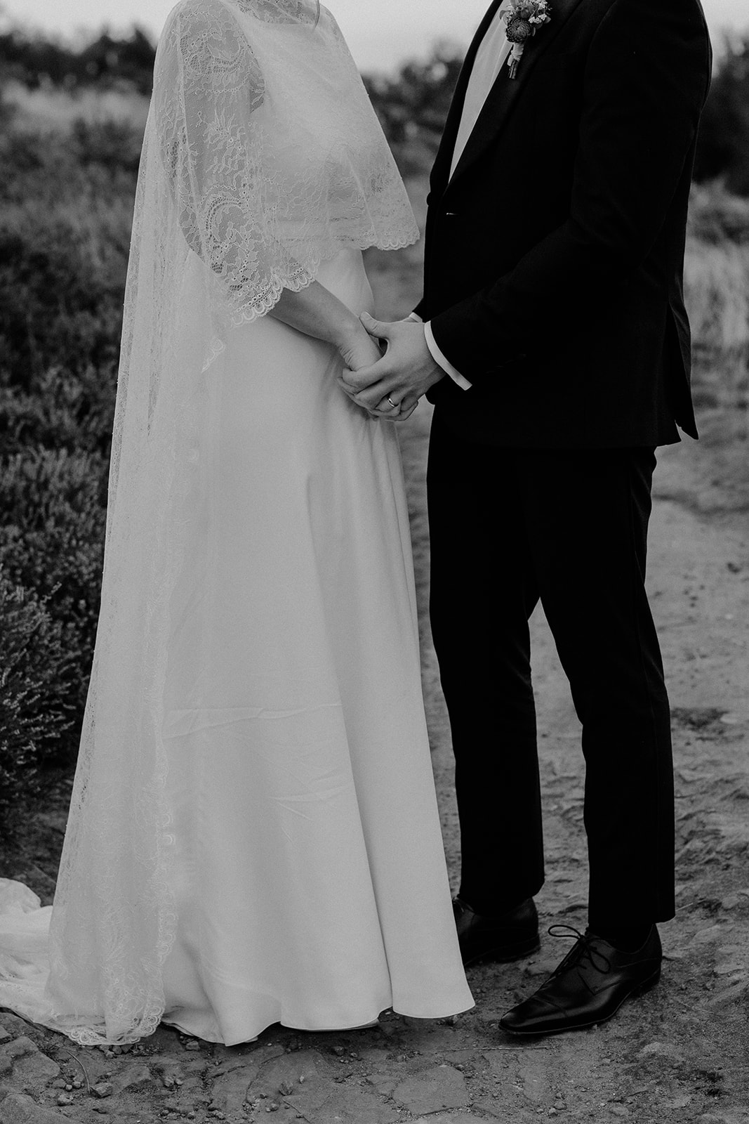 Bride and groom holding hands in quiet togetherness – natural Derbyshire wedding photography.