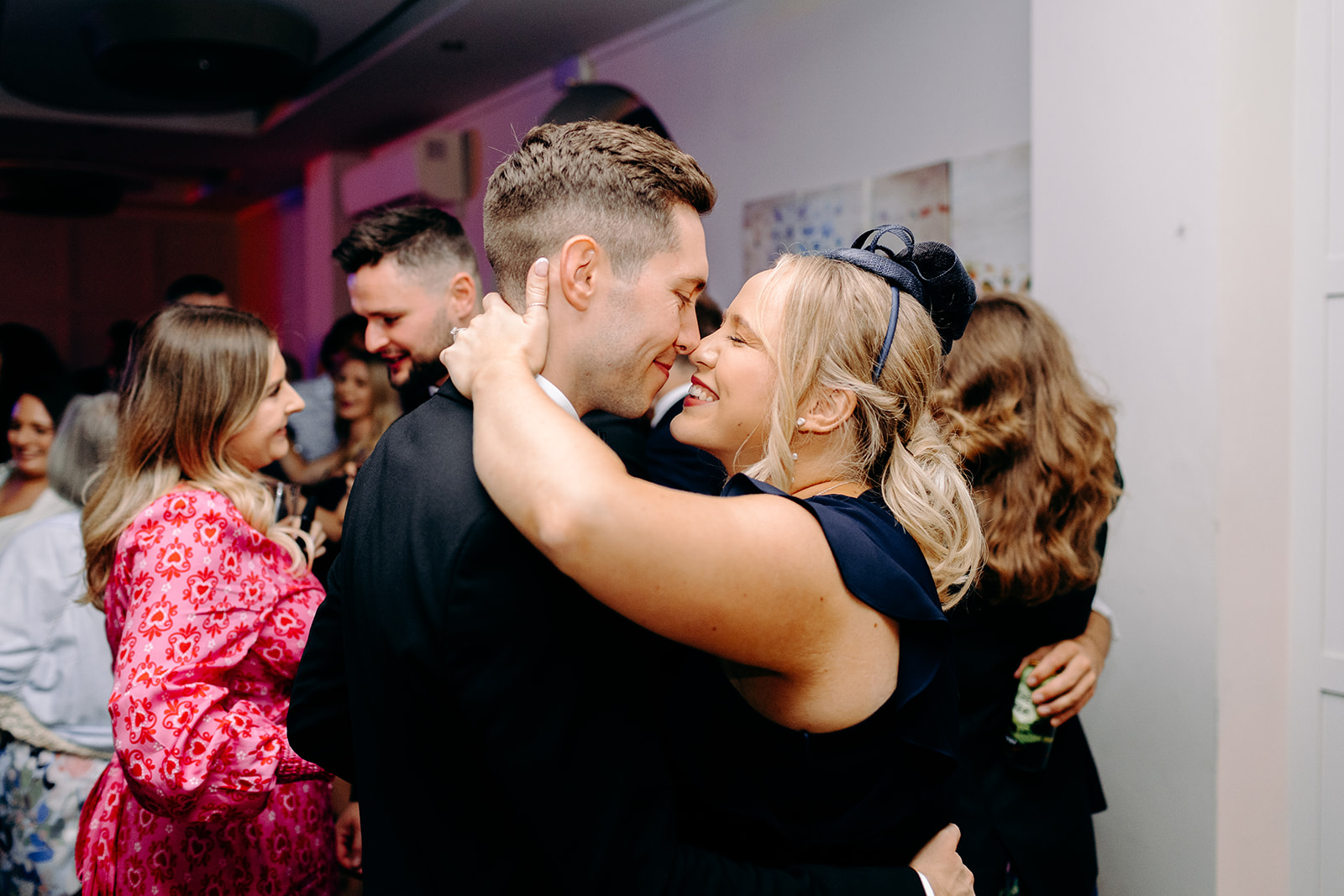 A candid group hug on the dance floor at Darwin Lakes Holiday Village during a lively wedding party.