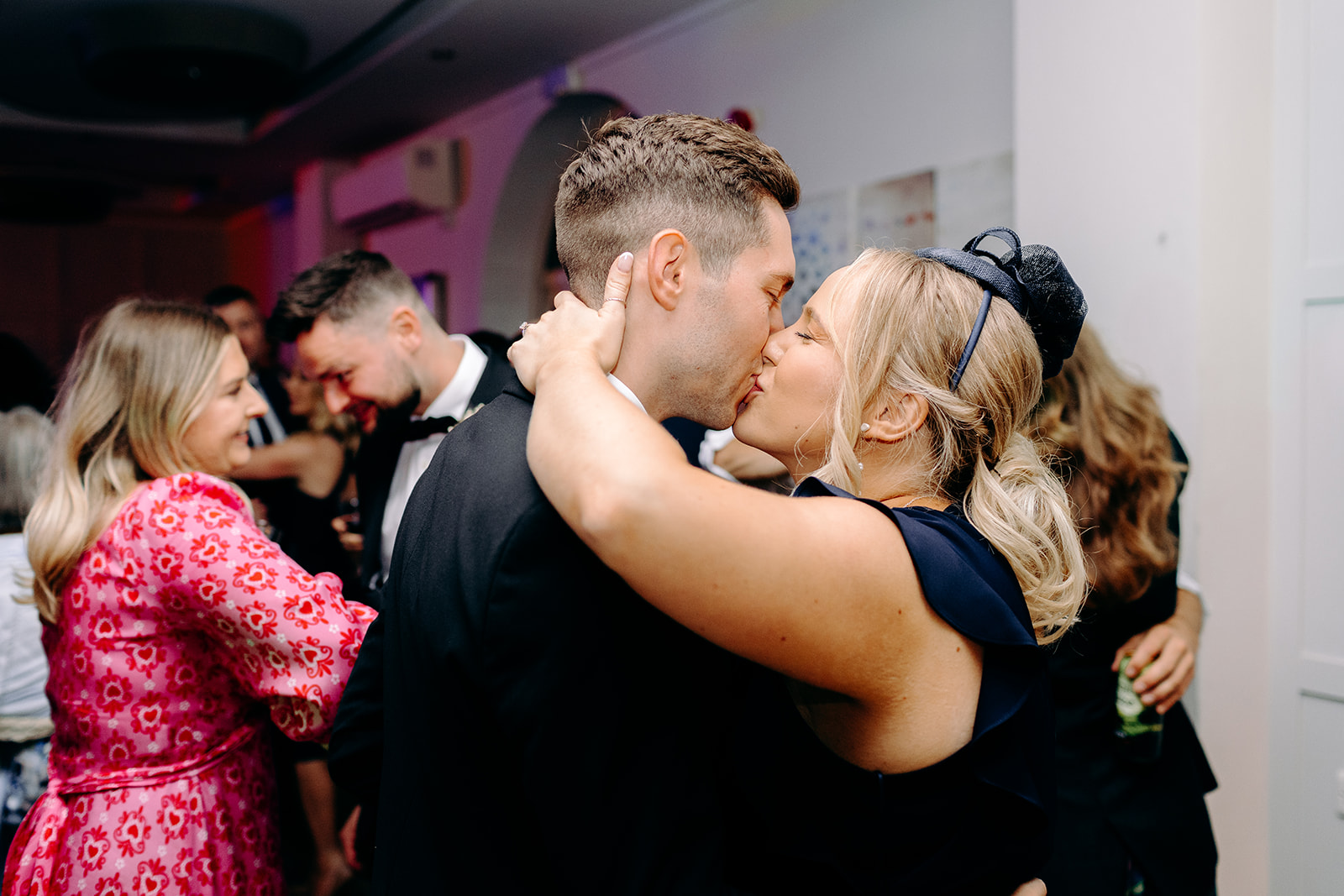 Romantic dance moment between two guests under warm ambient lighting in the reception room.