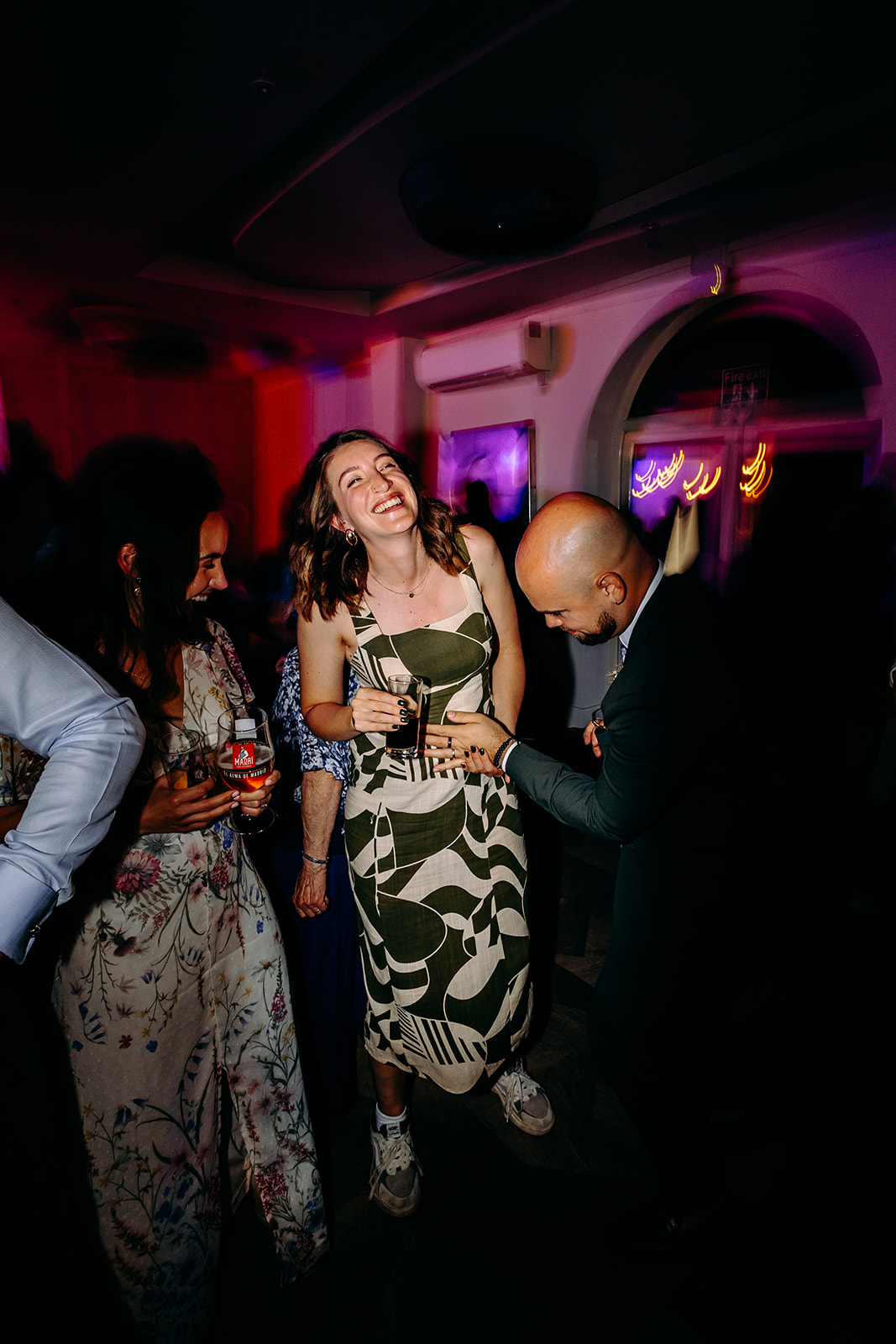 Guest spinning with joy on the dance floor in this colourful, fun wedding photography moment.