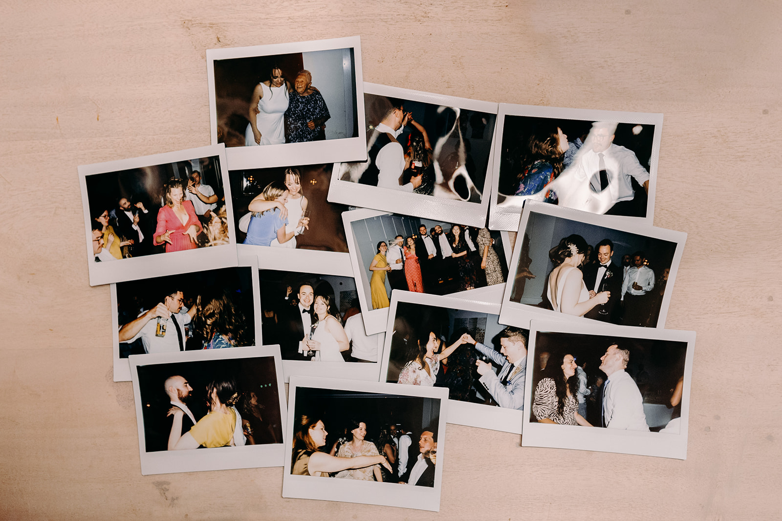 Flat lay display of instant photos capturing fun wedding reception moments.