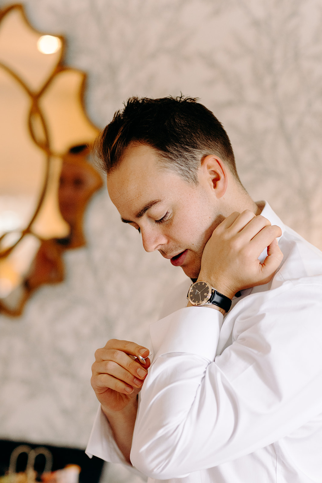 Candid groom portrait adjusting cufflinks, captured in natural light at Darwin Lake – relaxed wedding photography in the Peak District.
