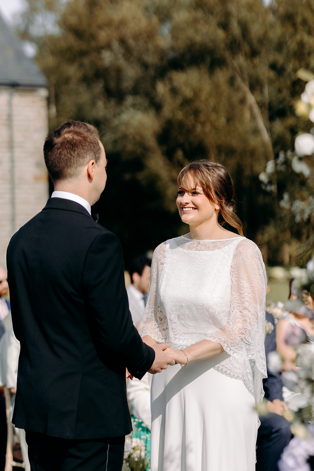 Bride smiling at the groom during lakeside wedding ceremony – relaxed and informal wedding in the Peak District.