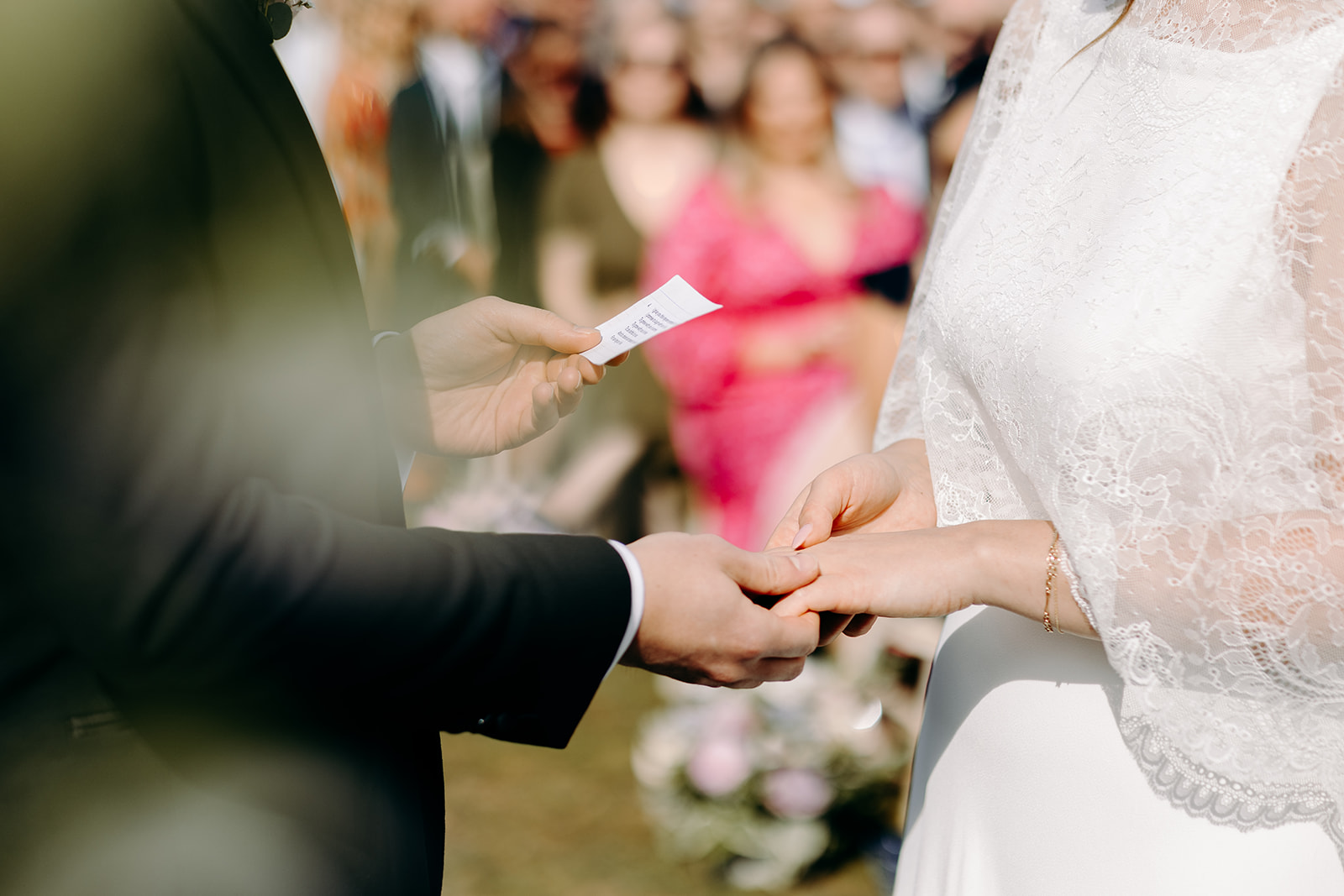 Detail shot of groom holding the bride's hand whilst we reads his vows to her, natural documentary style wedding photography.