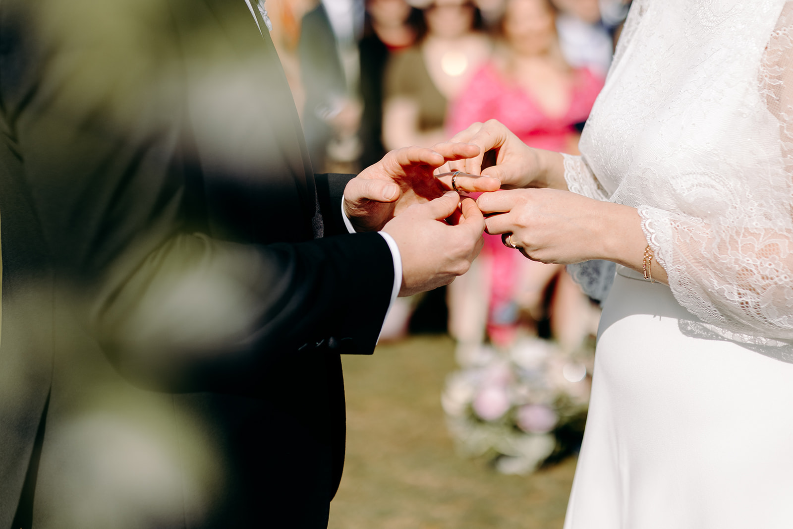 Detail shot of bride placing wedding ring on the groom's hand in this natural wedding photo at Darwin Lakes.