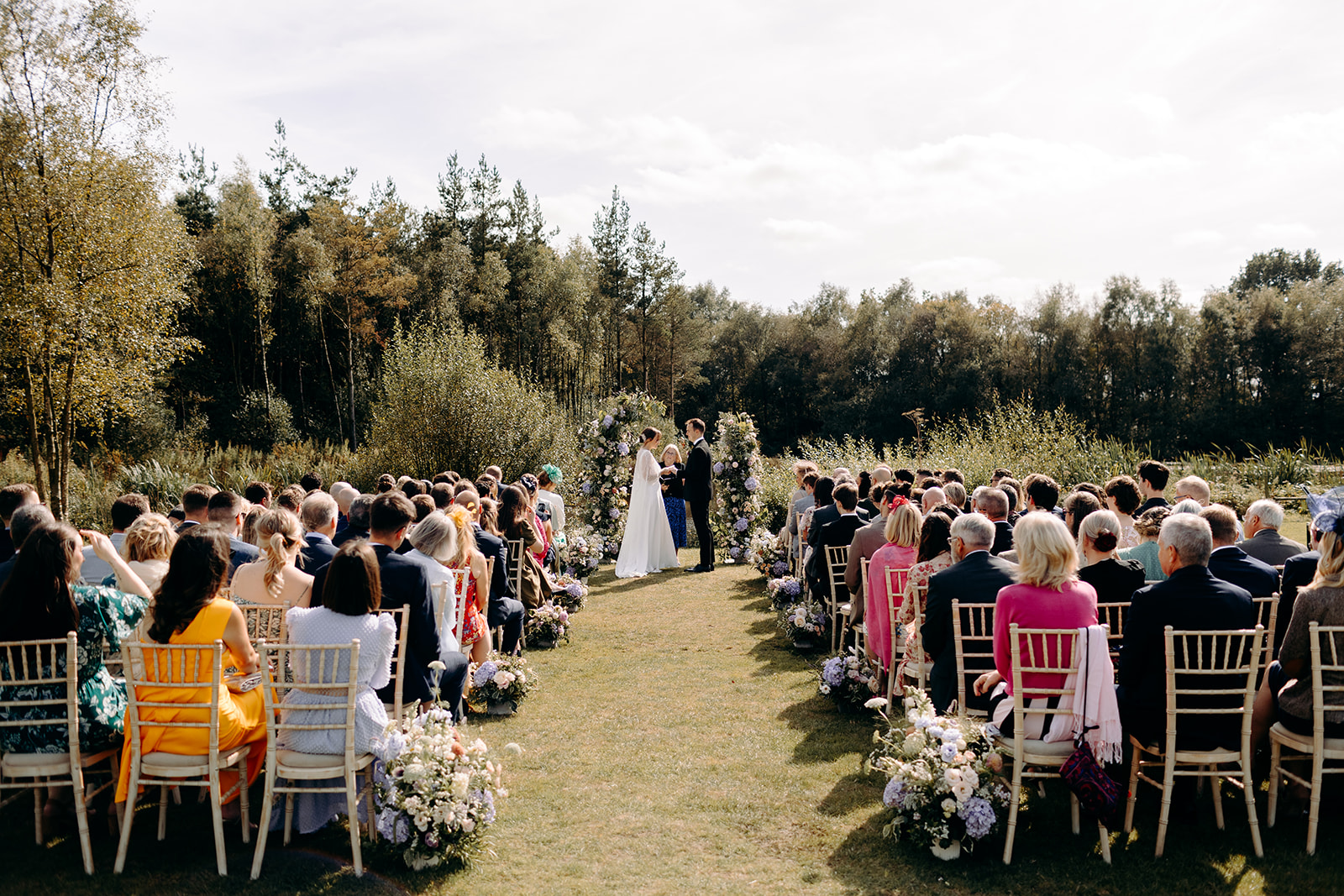Wide angle photo of the wedding ceremony, with Darwin Lakes in the background at this Peak District summer wedding.