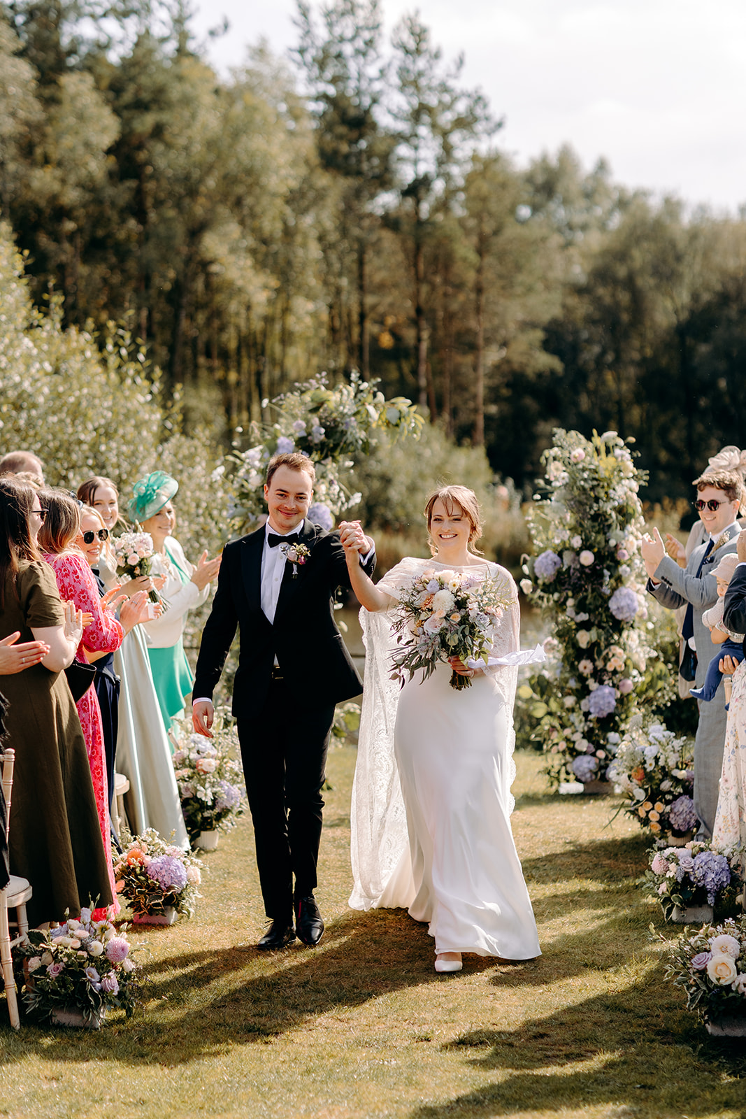 Bride and groom walking back up the aisle together - joyful and candid Derbyshire wedding photo.