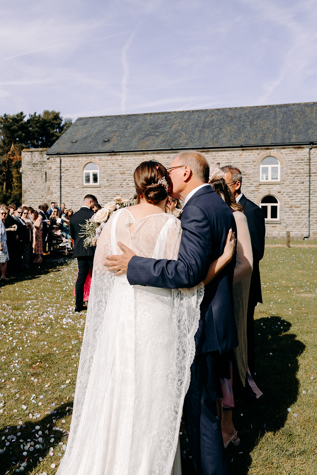 Candid wedding photography of the bride hugging her dad after her lakeside wedding ceremony at Darwin Lakes.