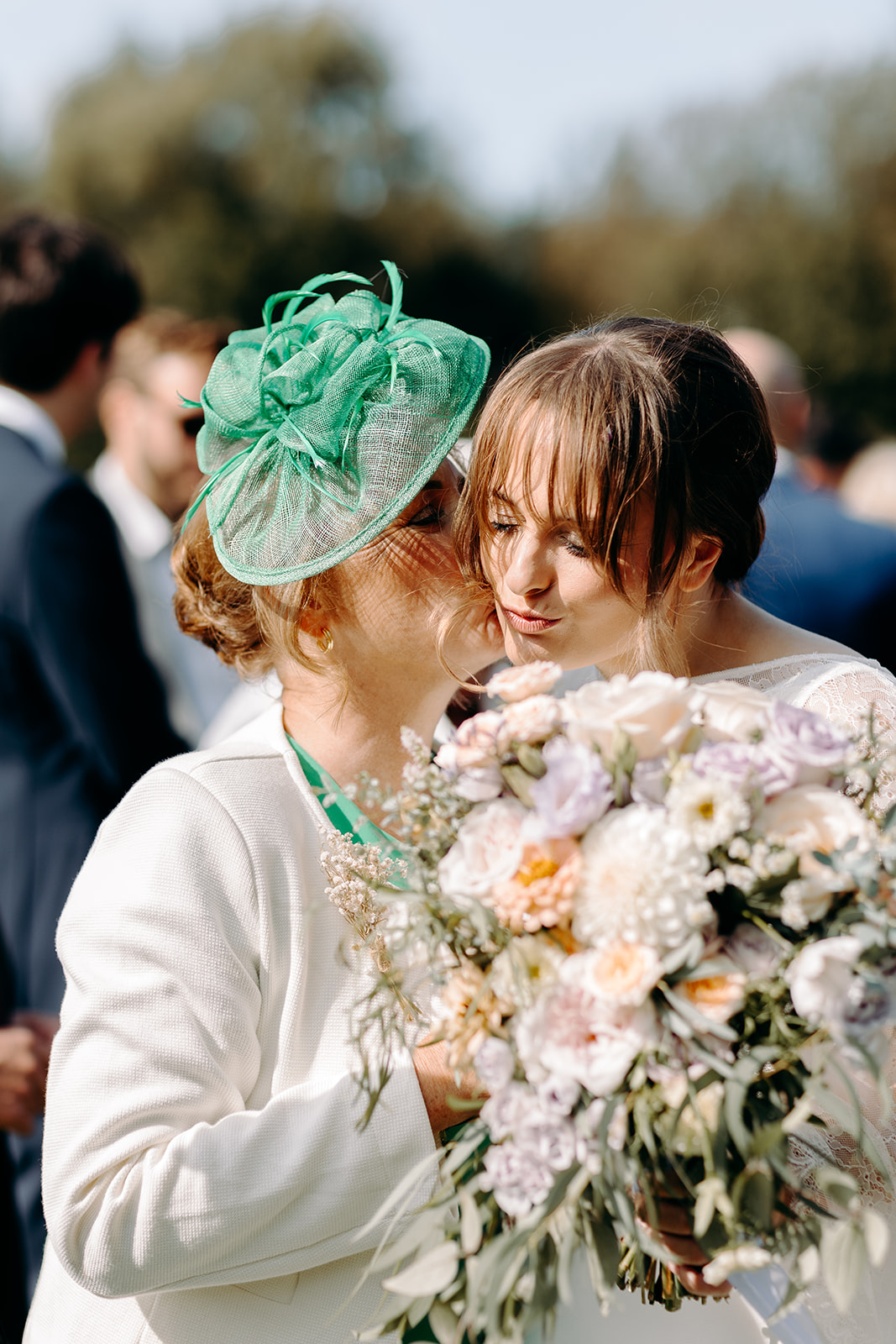 Mother of the bride kissing the bride, whilst holding her wild flower bouquet after her ceremony at Darwin Lakes.