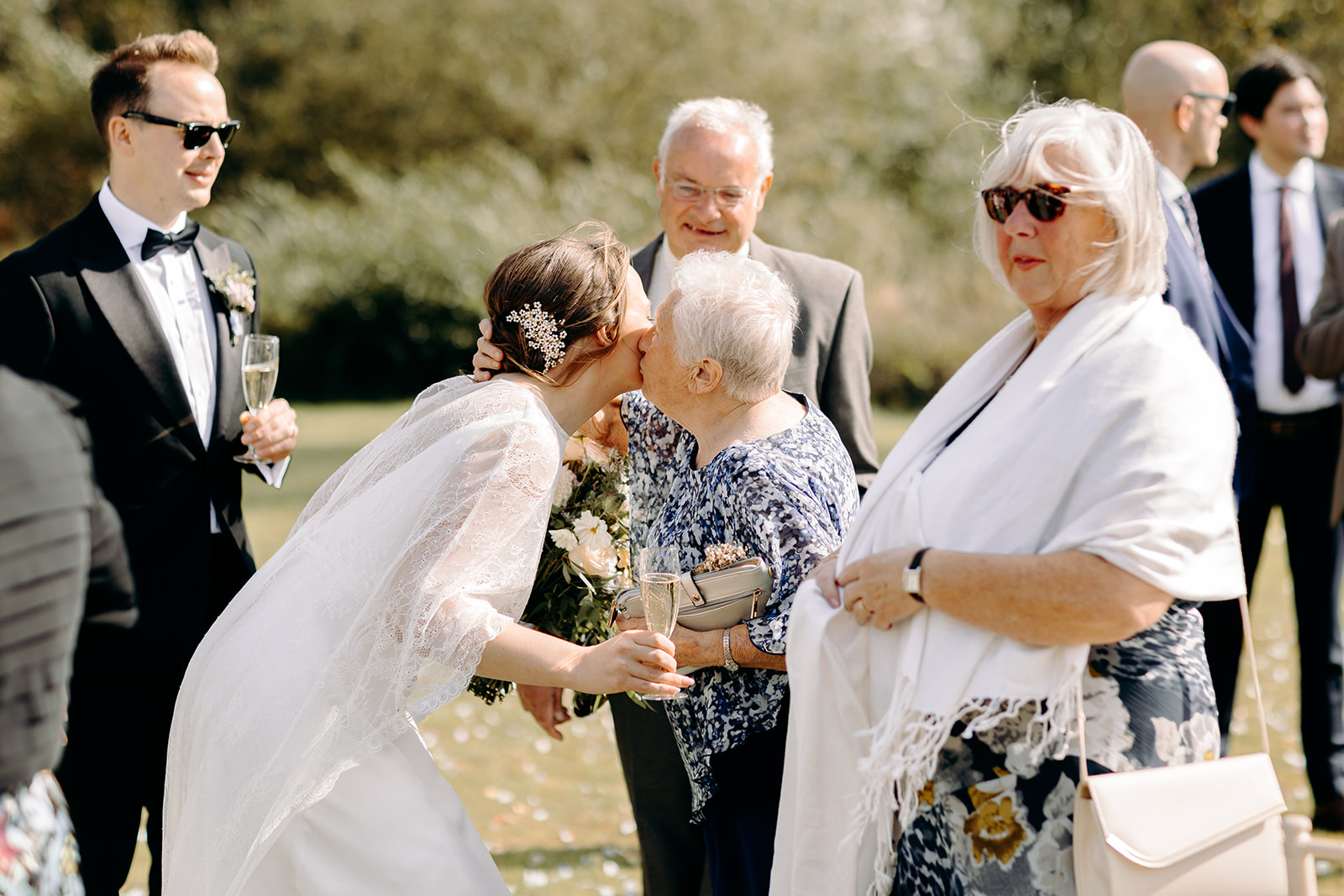 Bride greeting guests outdoors at Darwin Lake Holiday Village, natural Derbyshire wedding photography.