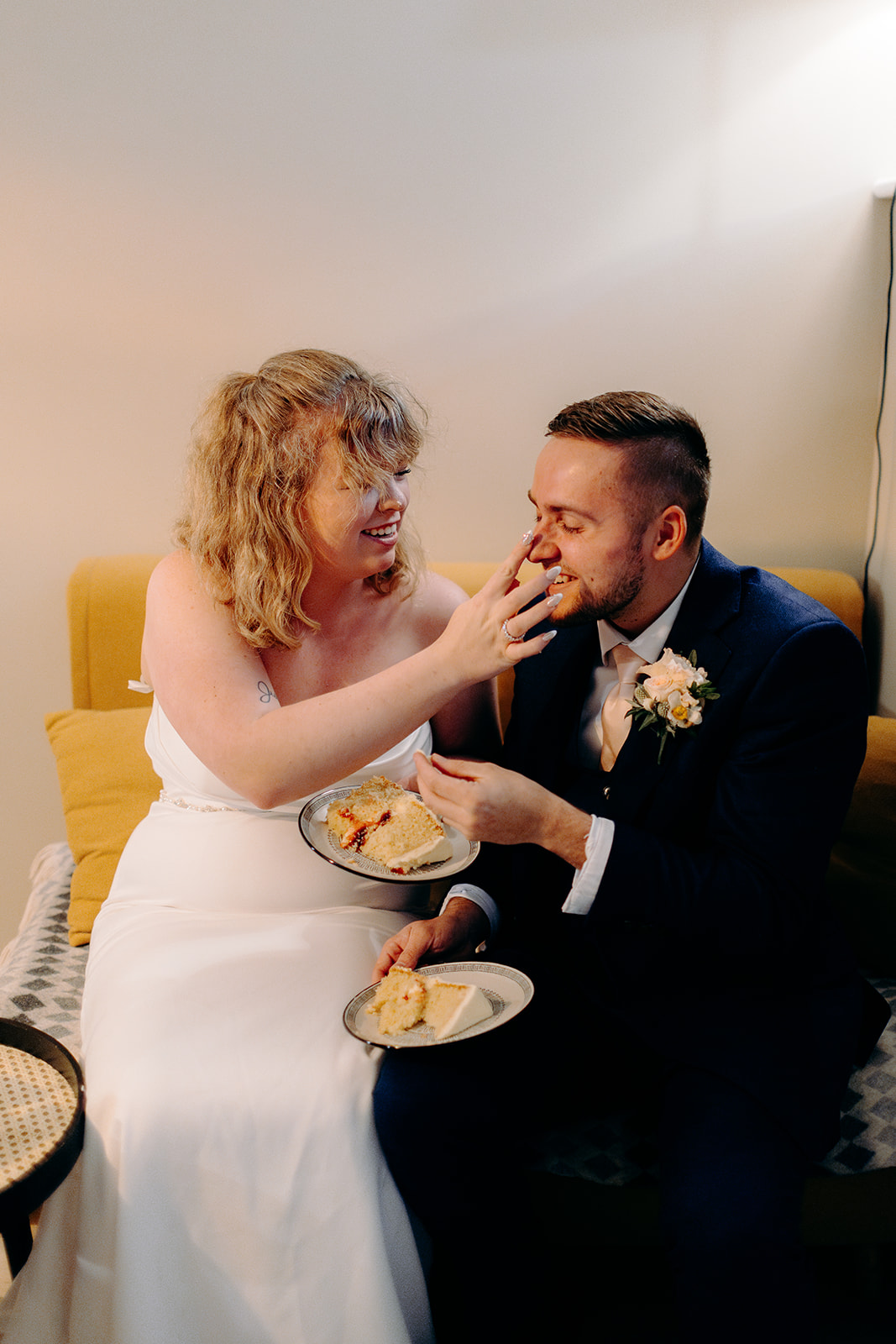 American bride and groom playing with icing on their wedding cake after eloping to the Fairy Pools