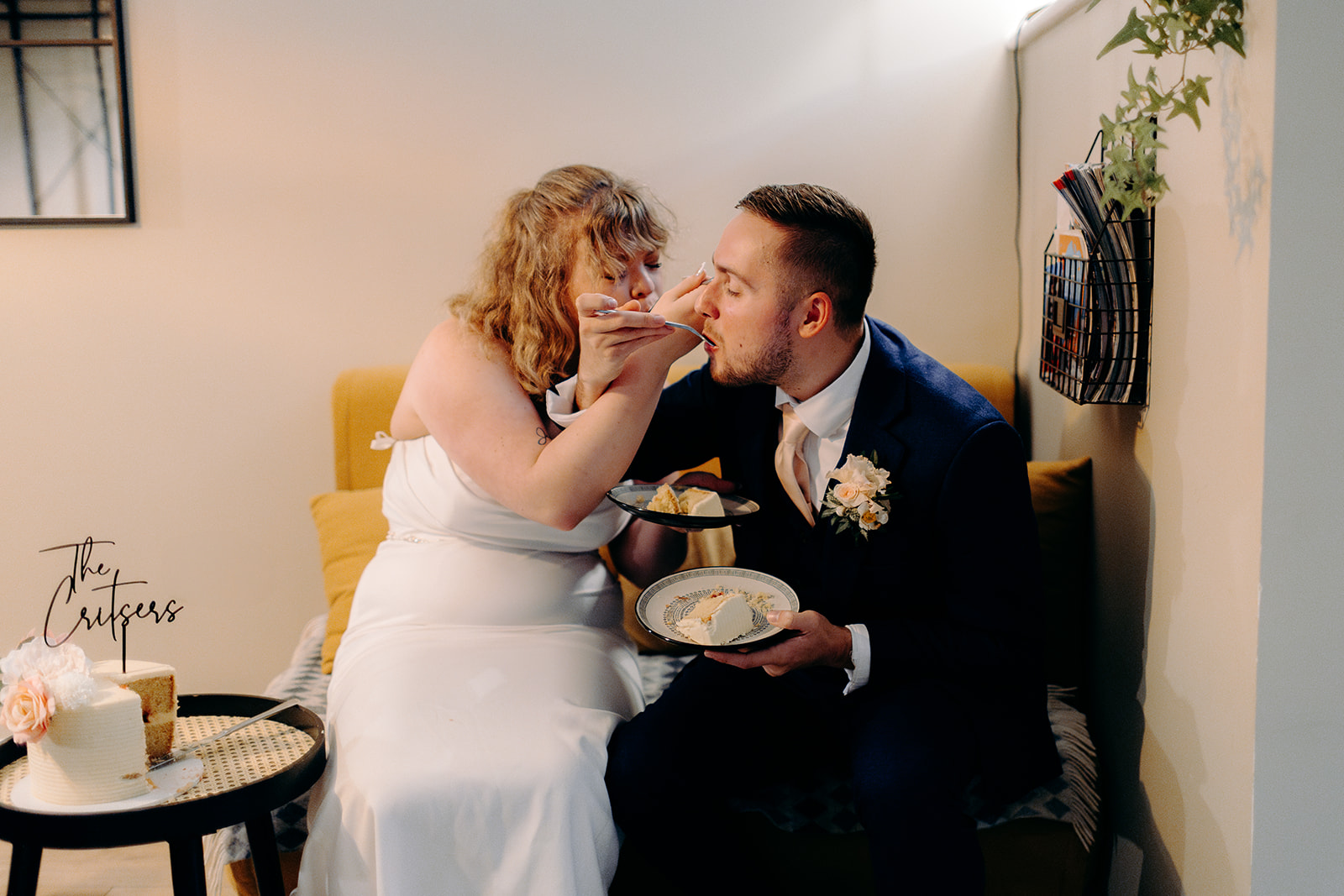 Bride and groom feeding each other their wedding cake in their cosy, Isle of Skye cottage
