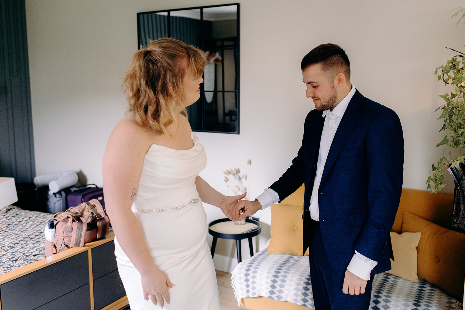 Groom helping the bride into her wedding dress before their Scottish Highlands elopement.