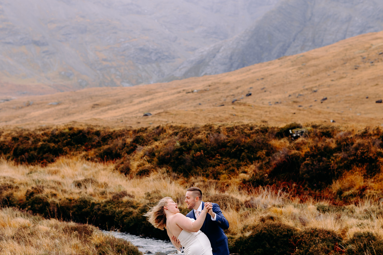 Bride and groom standing in a dramatic Highland landscape post-ceremony