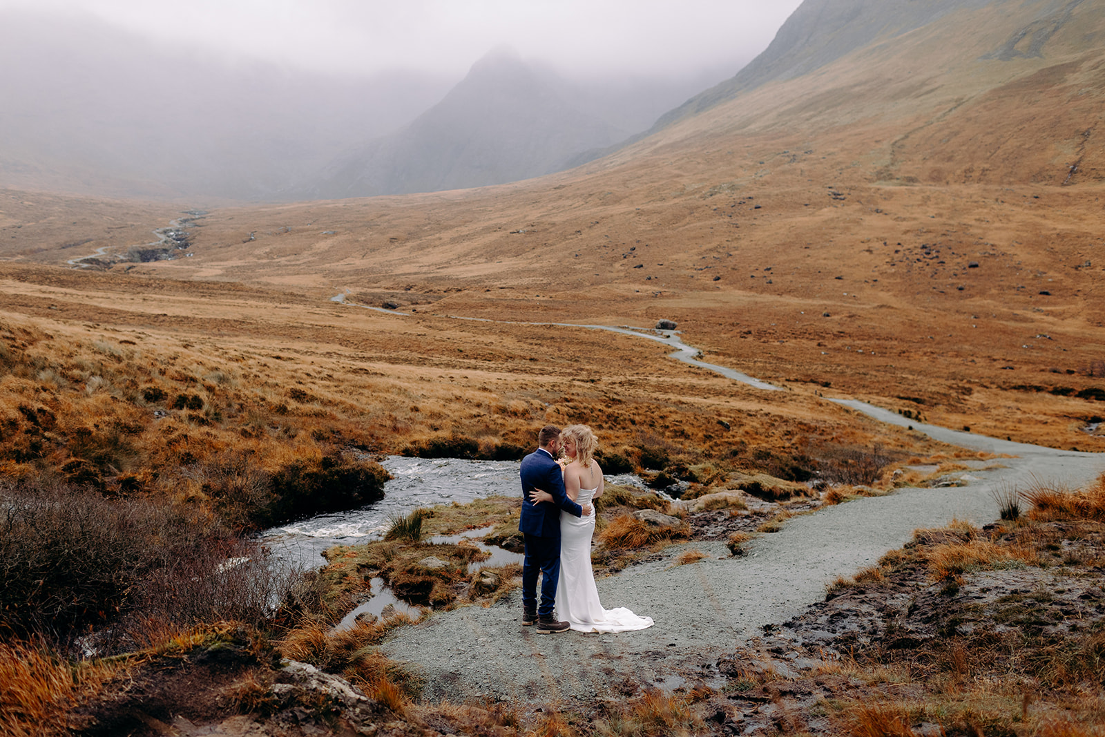 Isle of Skye elopement couple sharing a quiet moment surrounded by moody Highland views.
