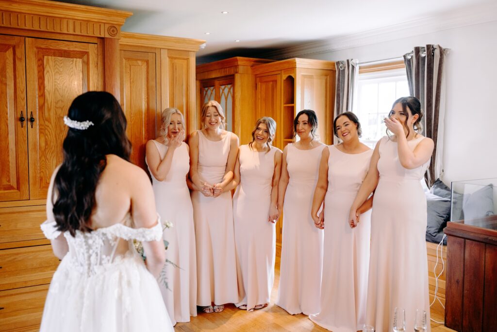 Bride having an emotional first look with her bridesmaids at Swancar Farm