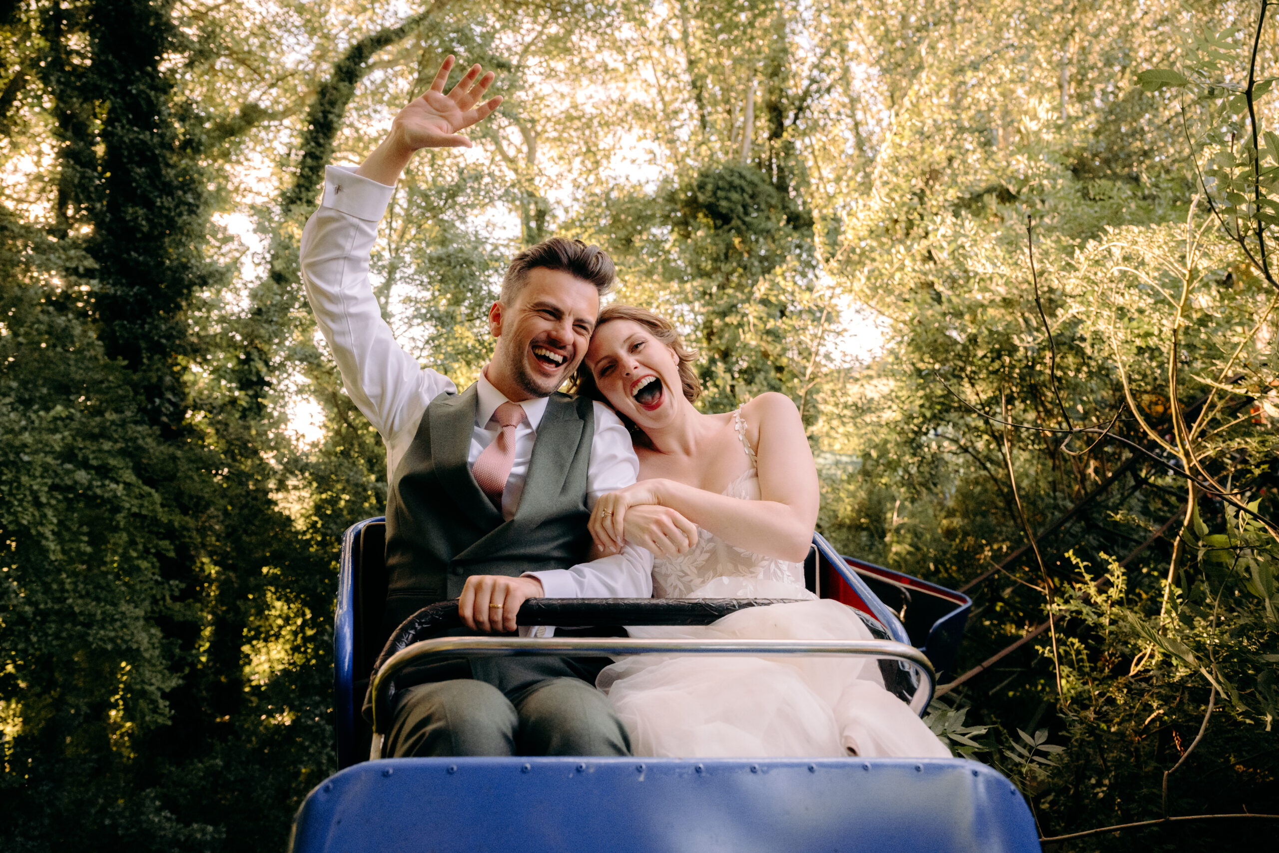 Fun wedding photography of bride and groom on a rollercoaster at a Marleybrook House, a UK wedding venue with a funfair