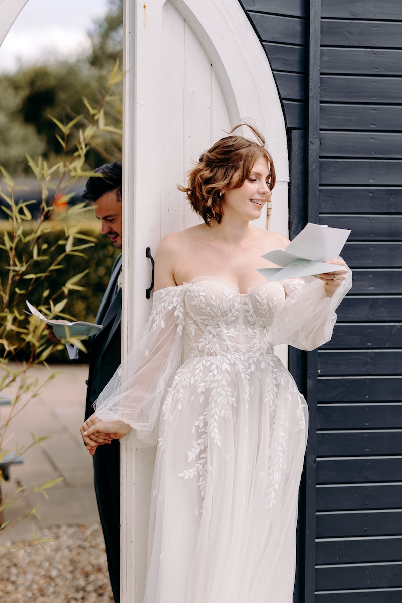 Bride holding a letter, preparing for emotional first look – private moment at a Marleybrook House wedding.