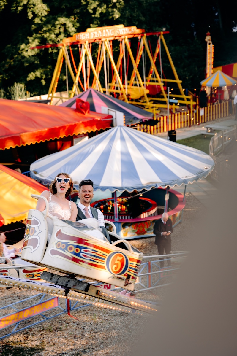 Bride and groom having fun on a ride at a UK wedding venue with a fairground