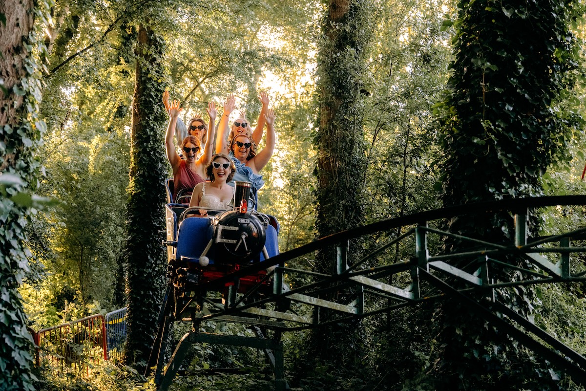guests wave from the rollercoaster, laughing as they’re spun in circles – a fun, candid shot from the reception.