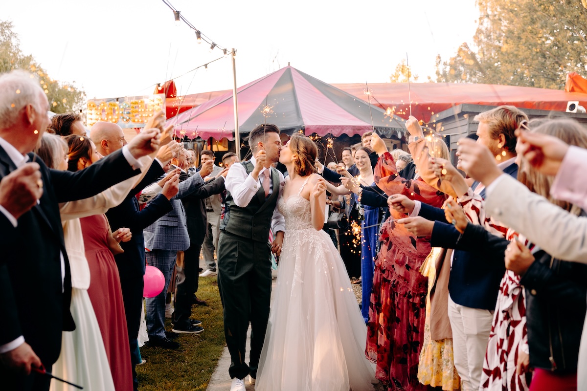 Bride and groom exit the Marleybrook House funfair with a sparkler tunnel, fun and natural wedding photography in Kent