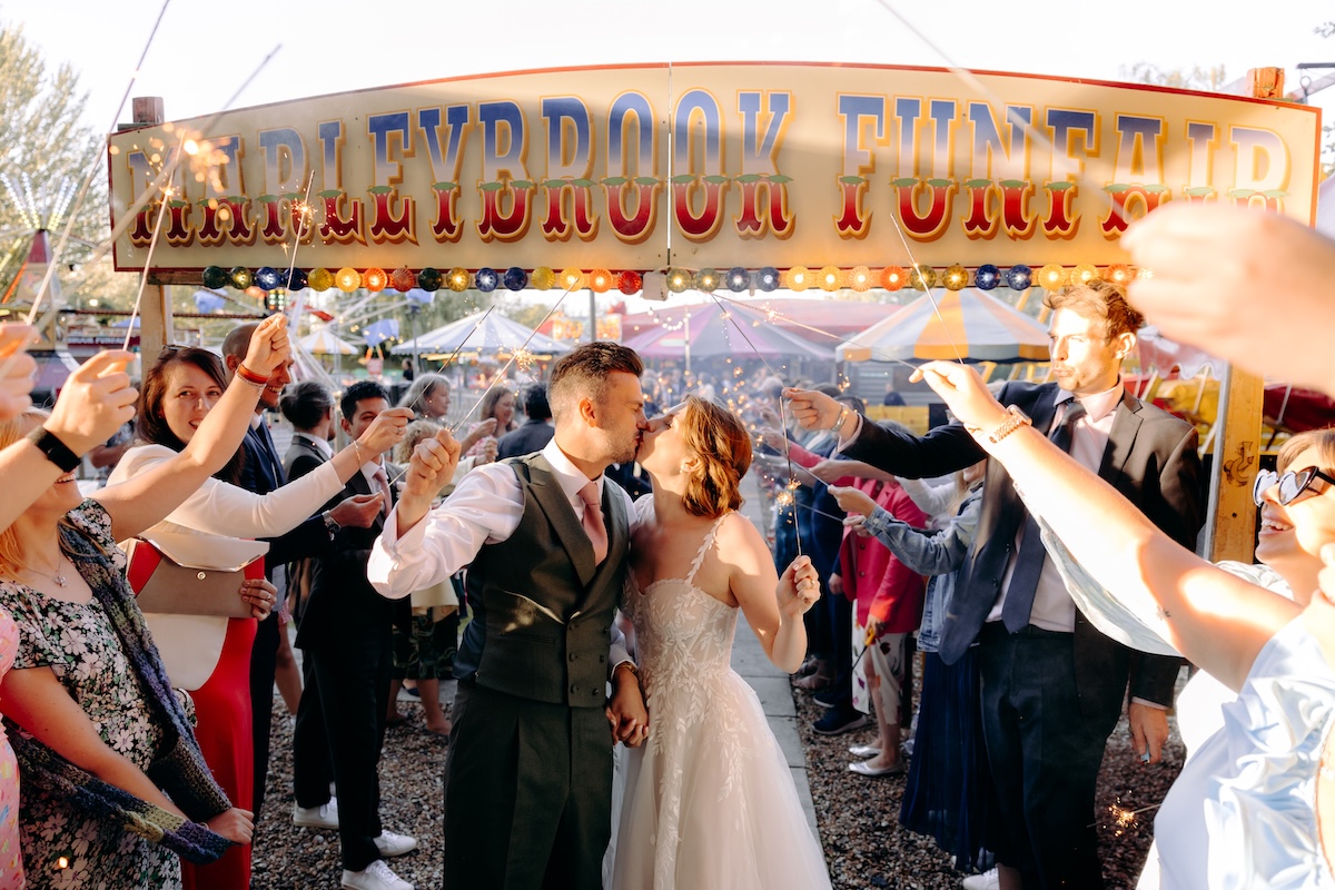 Bride and groom exit the Marleybrook House funfair with a sparkler tunnel, fun and natural wedding photography in Kent