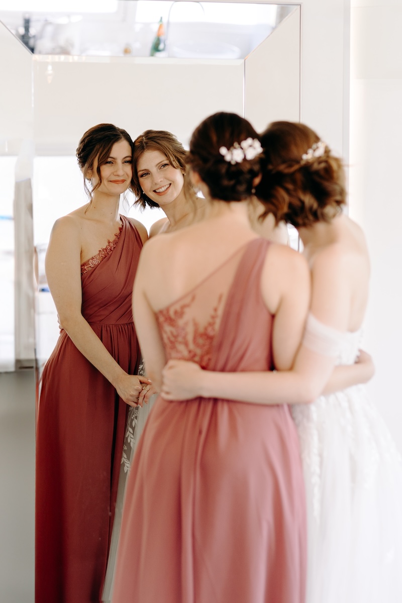 Bride smiling over her shoulder in soft light – elegant bridal portrait before outdoor ceremony at Marleybrook House.
