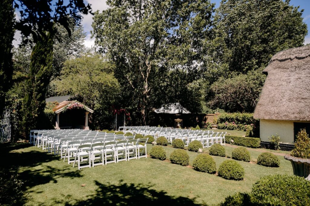 Thatched ceremony pavilion at Marleybrook House surrounded by gardens – outdoor wedding setup in Kent.
