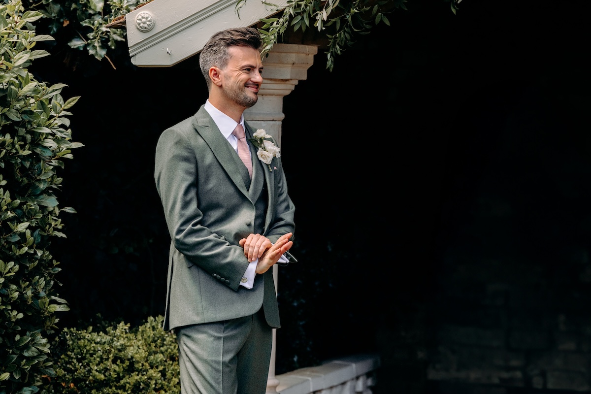 Groom smiling as he sees the bride – emotional reaction during outdoor ceremony at Marleybrook House.
