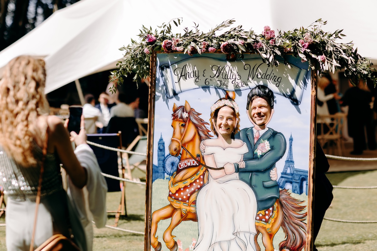 Fun wedding photo of guests posing behind a vintage carnival photo board at Marleybrook House.