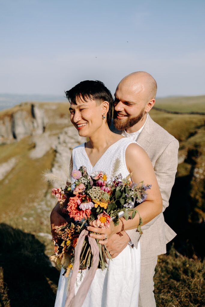 Peak District elopement photographer capturing a couple embracing with sweeping valley views.
