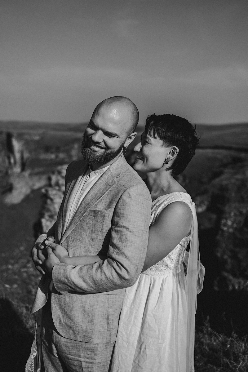 Black and white couple’s portrait on cliffs photographed by a Peak District elopement photographer.