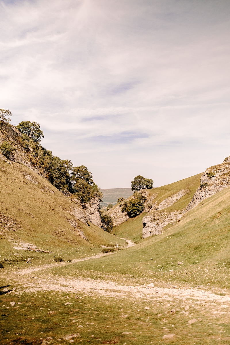 Wide view of the valley and cliffs forming the backdrop of this nature-focused Peak District elopement.
