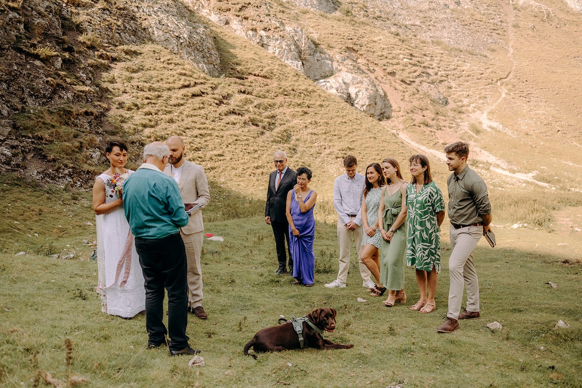 Guests gathered in a small semicircle while the couple exchange vows in the Peak District.