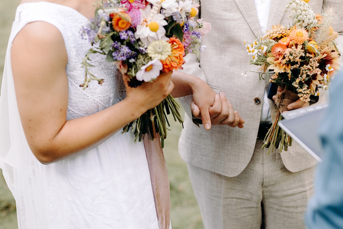 Groom holding the bride’s hands as they exchange vows in their natural Peak District elopement setting.
