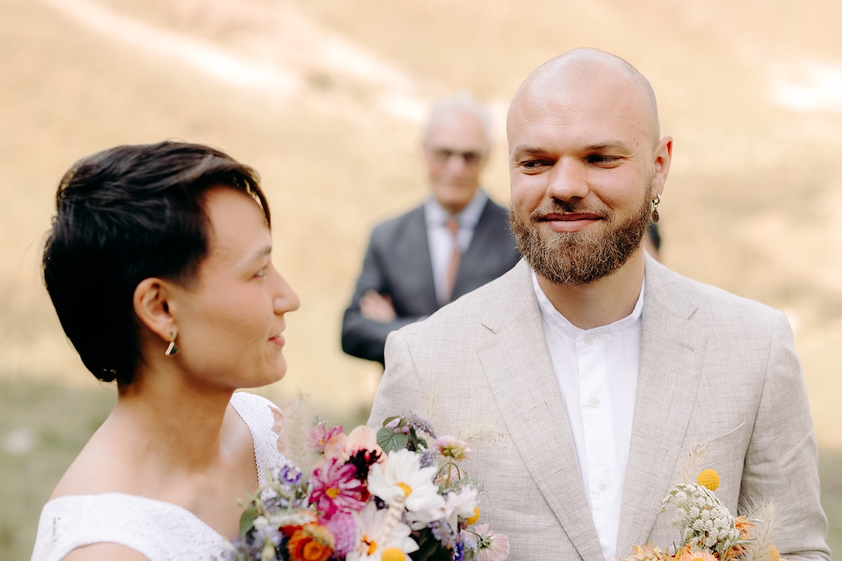 Bride smiling up at her partner during their vow exchange in the Peak District hills.