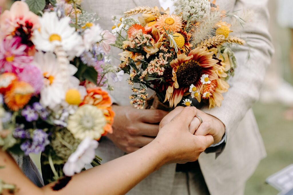 Close-up of the bride’s vibrant mixed-flower bouquet during the outdoor elopement ceremony.