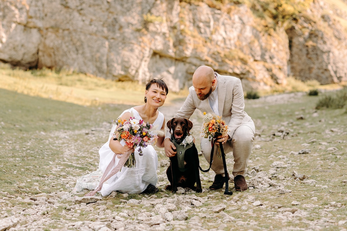 Eloping couple sitting on the ground with their two dogs during a relaxed Peak District elopement.