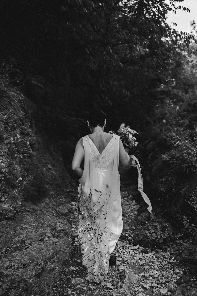 Black and white photo of couple walking through a wooded Peak District gorge during their elopement.