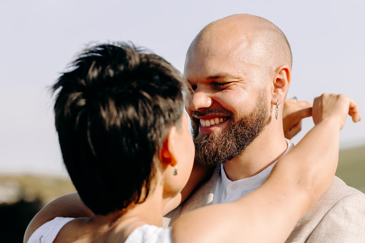 Close-up of a couple smiling at each other in warm light during their Peak District elopement.