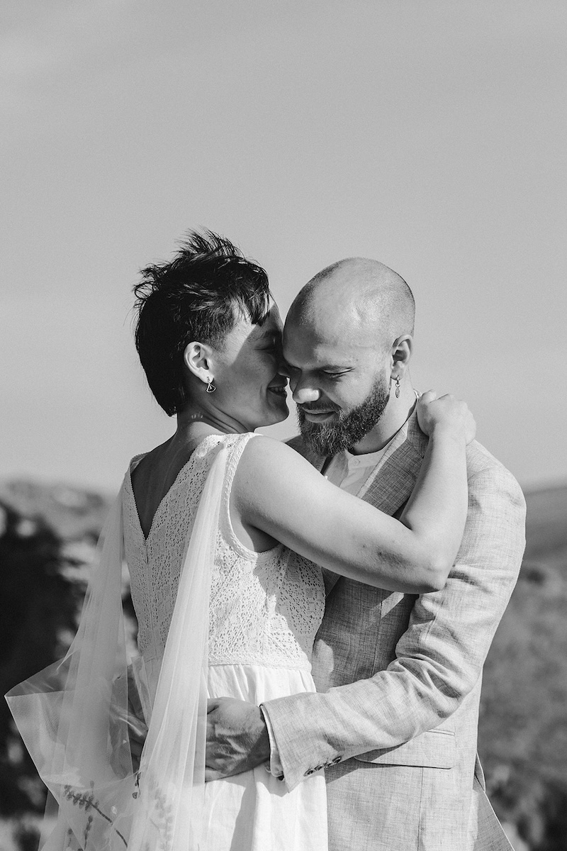 Black and white close-up of an eloping couple sharing an intimate moment outdoors.
